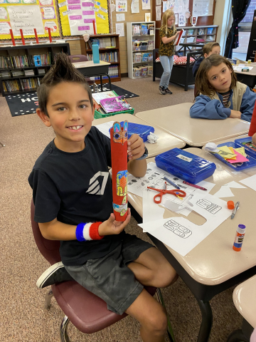 Third grade students making totem poles out of paper.