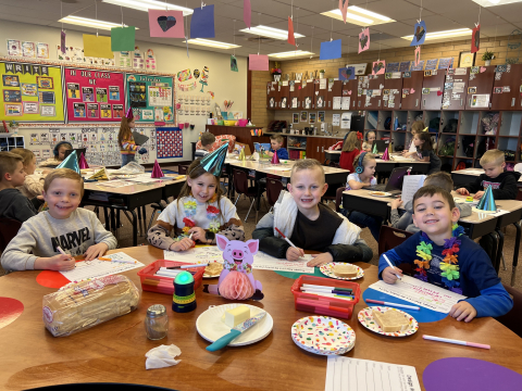 First graders eating buttered toast and doing a writing project.