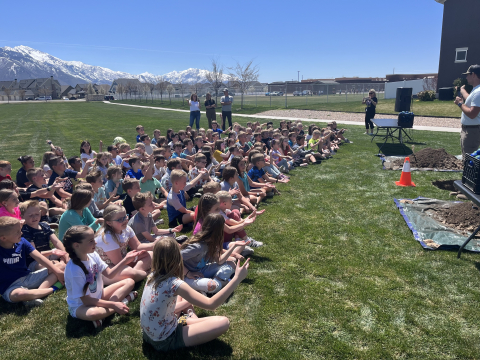 Students listening to a presentation on Arbor Day at the park. 