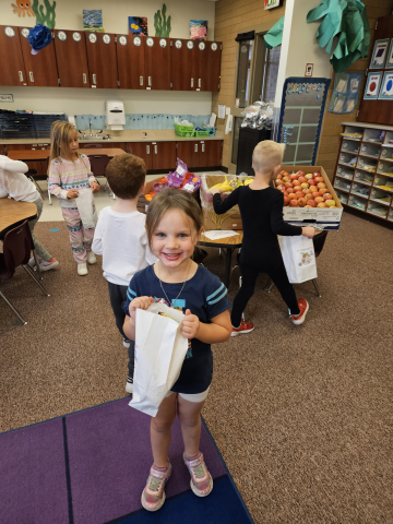 Kindergartener with a bag to put her "groceries."