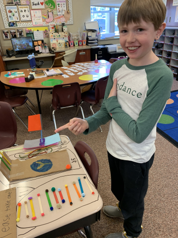 A second grader with the items that they made.