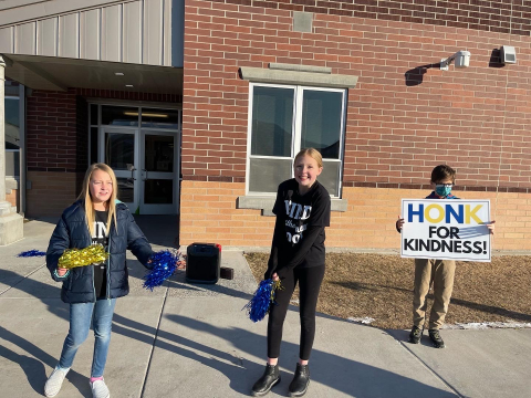 Students encouraging parents to honk for kindness!