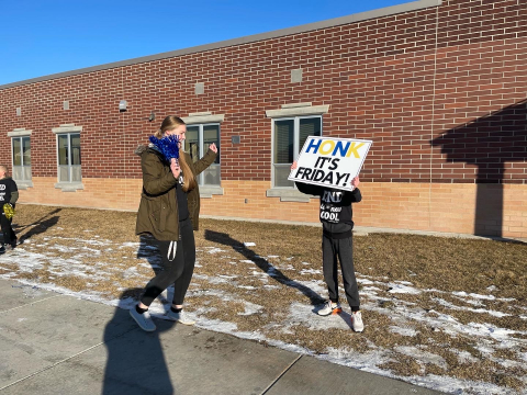 Students encouraging parents to honk for kindness!