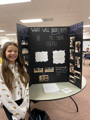 Student in front of science fair project.