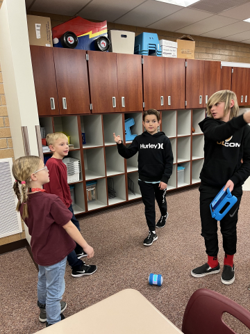 Fifth graders showing first graders how to program robots.