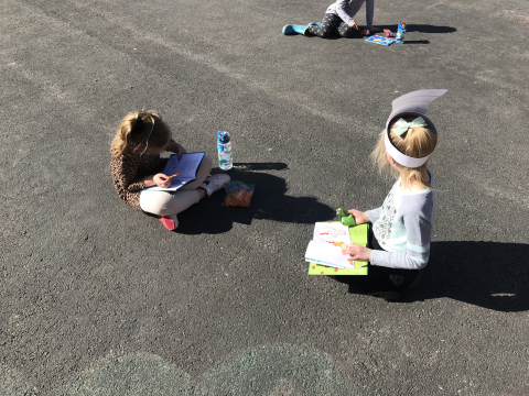 First graders reading outside.