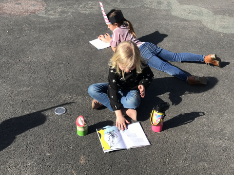 First graders reading outside.