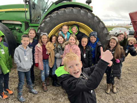 Second graders in front of a tractor.