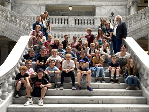 Students on the steps inside the Utah State Capitol building with Senator Hinkins.