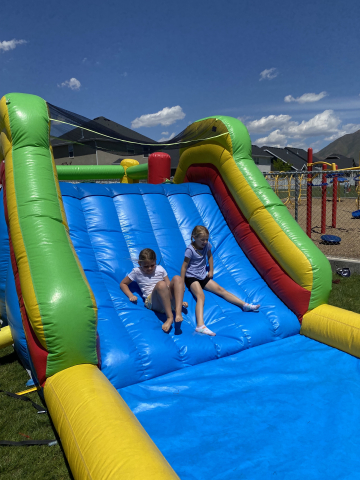 Students playing on a bouncy house at field day.