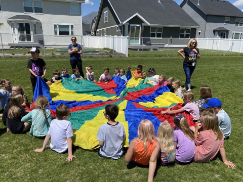 Students playing with a parachute at field day.