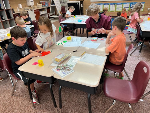 Maple Mountain High School football player playing games with second graders.