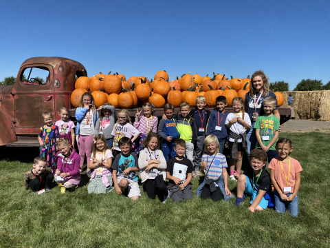 Students standing in front of a truck with pumpkins.
