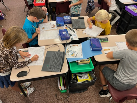 Students using chromebooks and working in groups to learn about Life Cycles.