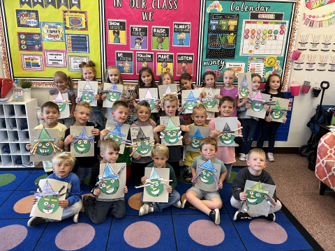 First grade students holding up work.