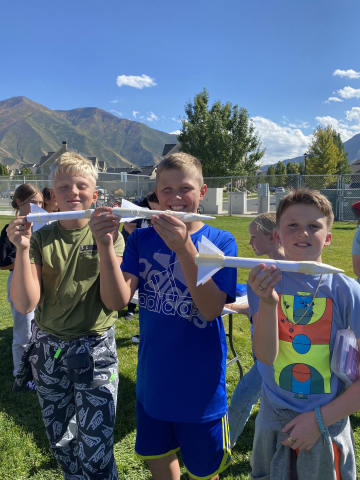 Students showing their paper rockets.