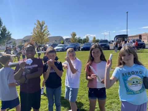 Students showing their paper rockets.