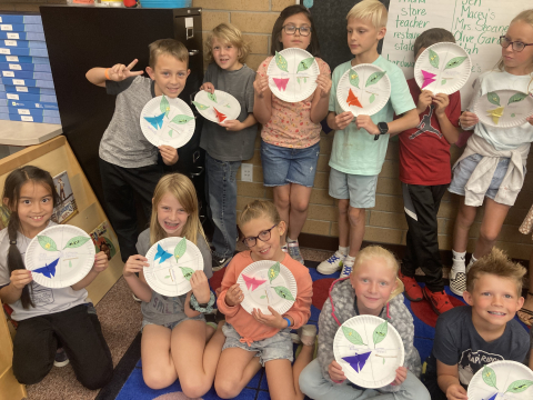 Students holding up their butterfly life cycle project.