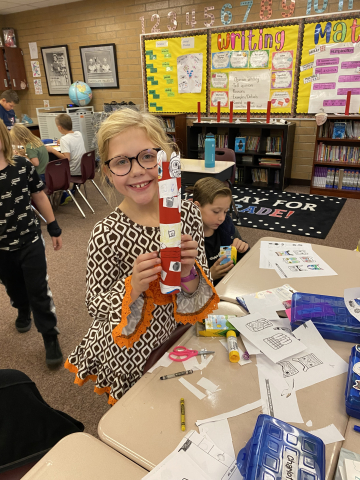 Third grade students making totem poles out of paper.