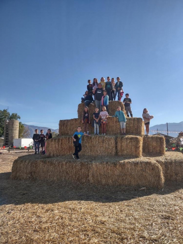 Students playing on large haystack.