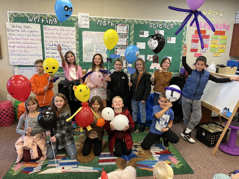 Students holding their balloon puppets.