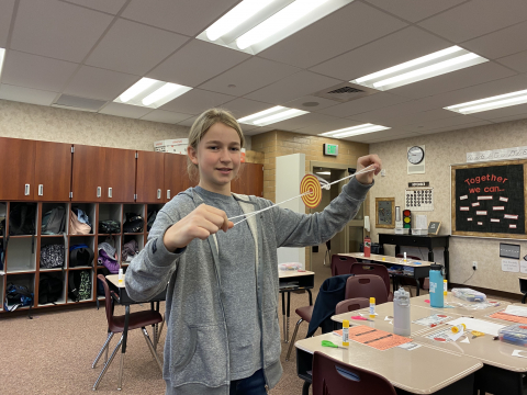 Student playing with a whirligig.