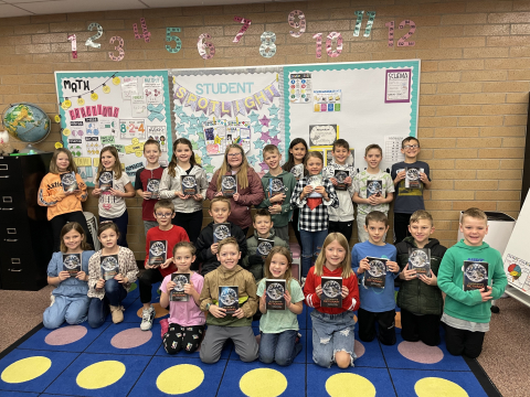 A class of third graders holding their dictionaries.