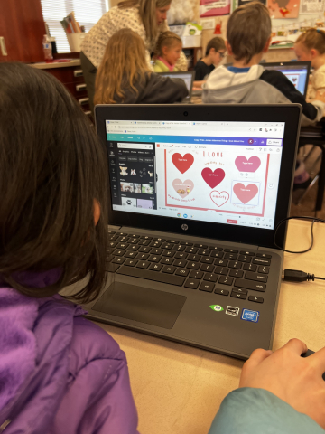 Students working on chromebooks to design Valentine's Day cards.