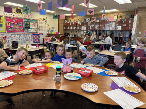 First graders eating buttered toast and doing a writing project.