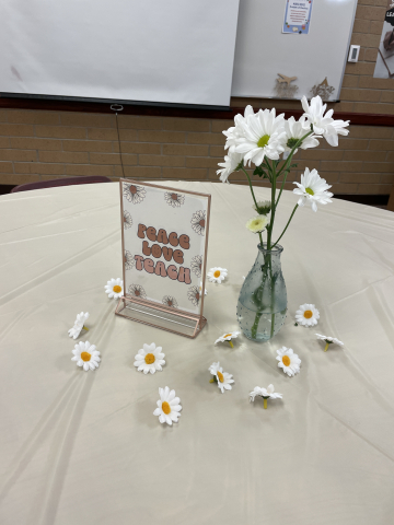Table decorations: flowers and peace/love/teach signs.