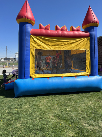Students playing outside in the bounce house.