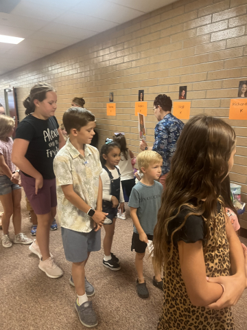5th grade students helping kindergarten students in the halls during lunch.