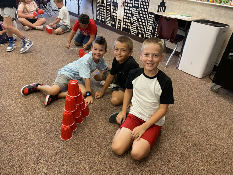 Students stacking red cups.