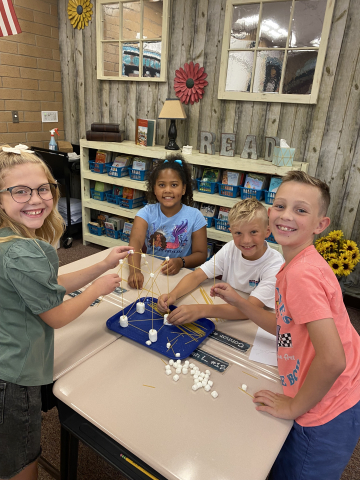 Students making a tower out of spaghetti and marshmallows.
