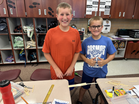 Students working together to make a bridge out of popsicle sticks.