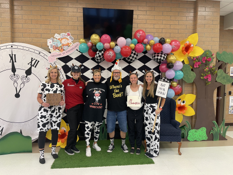 Fourth grade teachers dressed as cows, chickens, and a chick fli a worker.