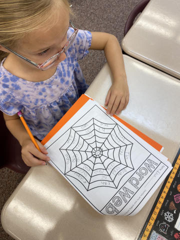 Writing heart words on a spider web.