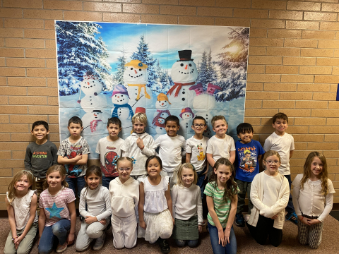 Class picture in front of snowman picture.