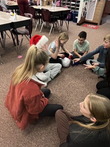 Students sitting on the floor and playing a game.