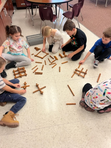 Students playing with Lincoln Logs.