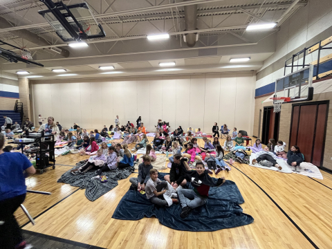 5th grade students on gym floor watching the movie.