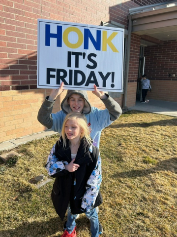 5th grade students holding "Honk for Kindness" sign.