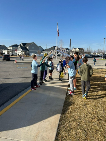 Students making a tunnel for kids to go under during Honk for Kindness.