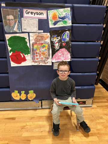 A student in front of their artwork.