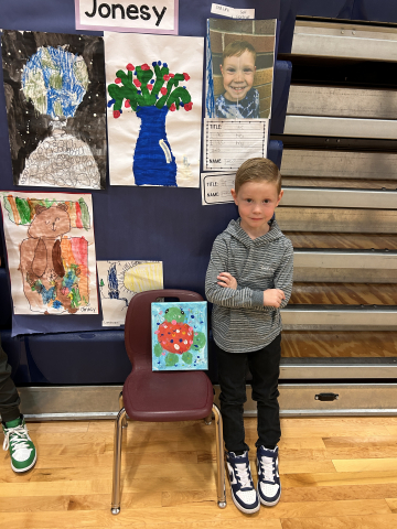 A student in front of their artwork.