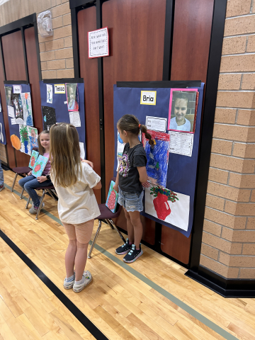 A student talking to other students about their artwork.