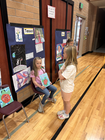 A student talking to other students about their artwork.