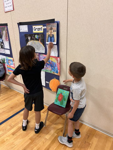 A student talking to other students about their artwork.