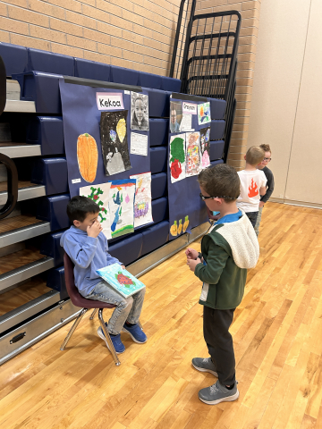 A student talking to other students about their artwork.