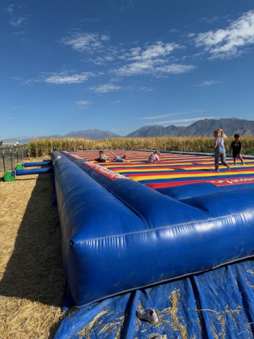 Students bouncing on the air trampoline at the pumpkin patch.